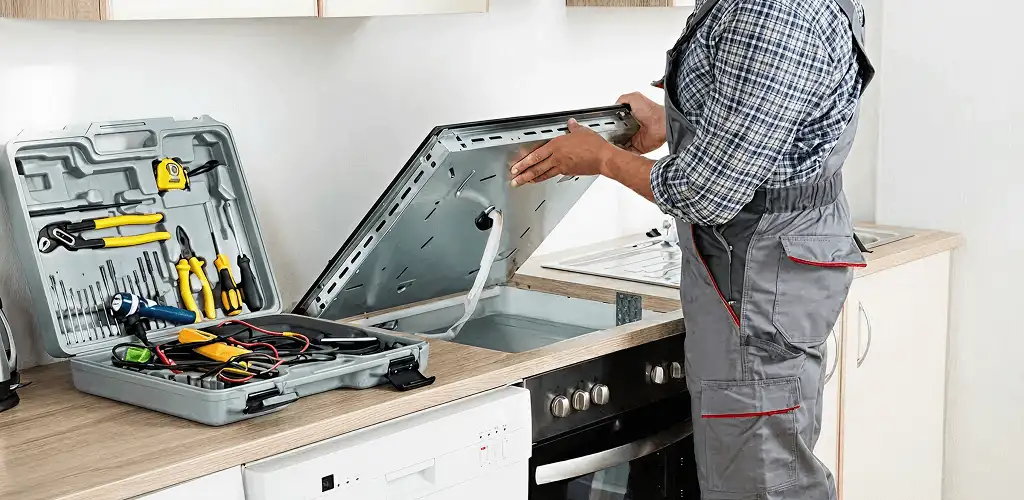 Handyman repairing a cooktop and checking wiring connections in Huntsville, AL
