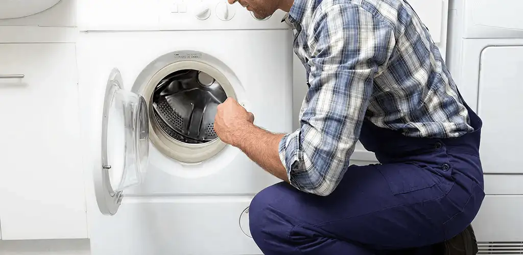 Handyman inspecting a dryer drum and internal parts for repair in Huntsville, AL