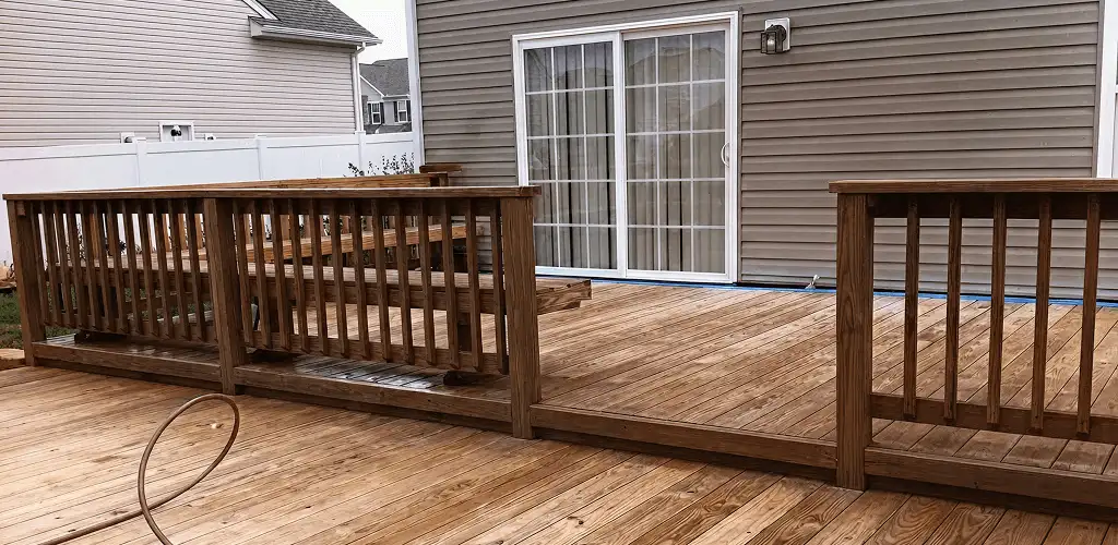 Deck sealing service protecting a backyard wood deck and railings in Huntsville, AL