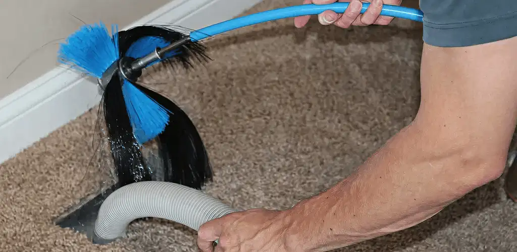 Dryer vent cleaning technician brushing lint from a vent line in Huntsville, AL