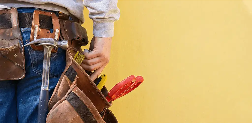 Handyman with tool belt ready for home repairs and maintenance in Huntsville, AL
