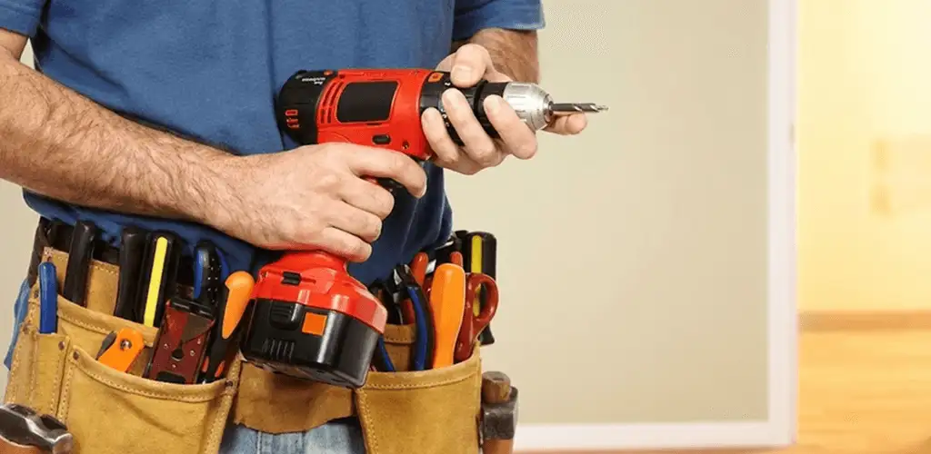 Handyman holding a power drill for home repairs and installations in Huntsville, AL