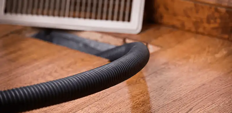 Air duct cleaning hose inserted into a floor vent for ductwork cleaning in Huntsville, AL