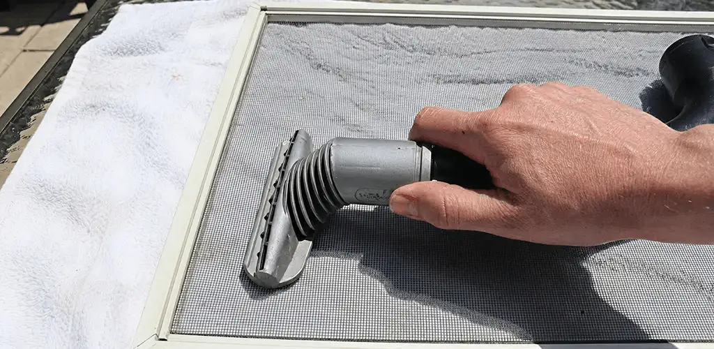 Window screen repair cleaning and fixing a damaged screen mesh in Huntsville, AL